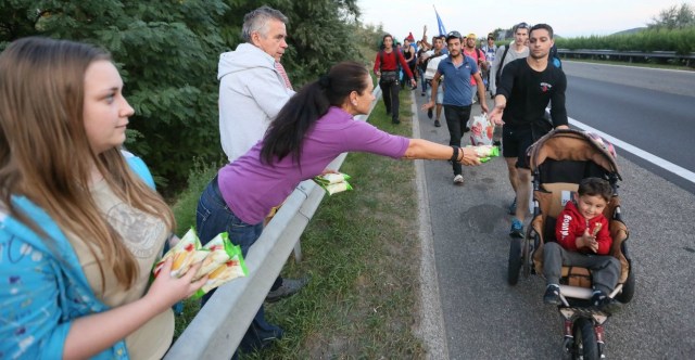 Sept. 4, 2015 - Bicske, Hungary - People on the sidelines pass out provisions as hundreds of migrants walk along the the motorway from Budapest north towards Austria. (Credit Image: © Paul Hackett/London News Pictures via ZUMA Wire)