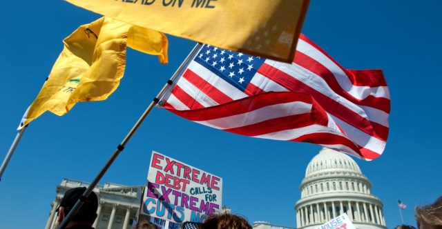 UNITED STATES – APRIL 6: Tea party activist on the East Front of the U.S. Capitol hold up signs and flags during a rally on Wednesday, April 6, 2012, days before a possible federal government shutdown. (Photo By Douglas Graham/Roll Call)